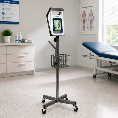 Tensiómetro digital profesional Yuwell YE680E Dual ambientado en consultorio clínico moderno con su pedestal de transporte.